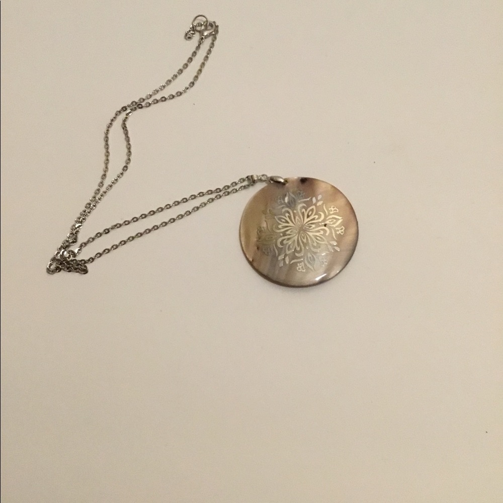 Round pendent with silver design on necklace